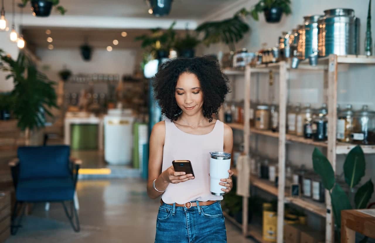 Shot of a young woman using a smartphone while shopping.